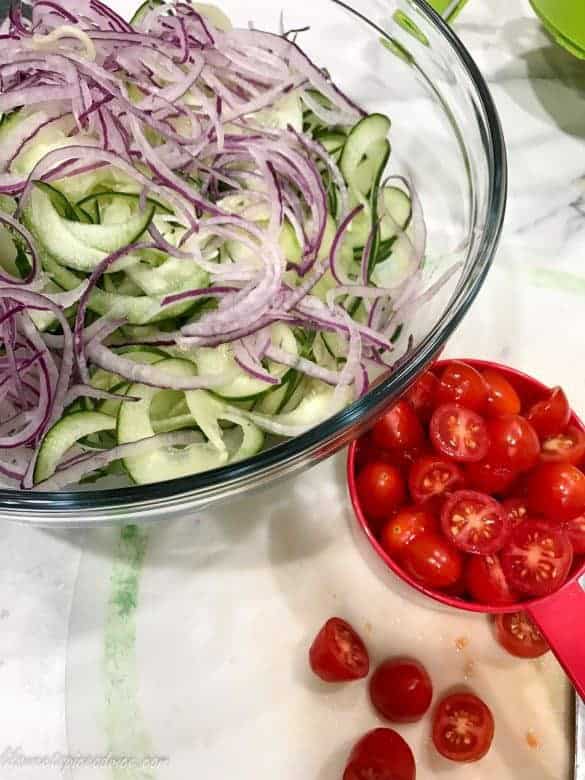Spiralized Cucumber Tomato Salad -- This Spiralized Cucumber Tomato Salad is the perfect raw vegetable salad to end the summer with! Cucumber noodles, grape tomatoes, and red onions are tossed in a Thai Basil Ginger Vinaigrette. -- lilsweetspiceadvice.com