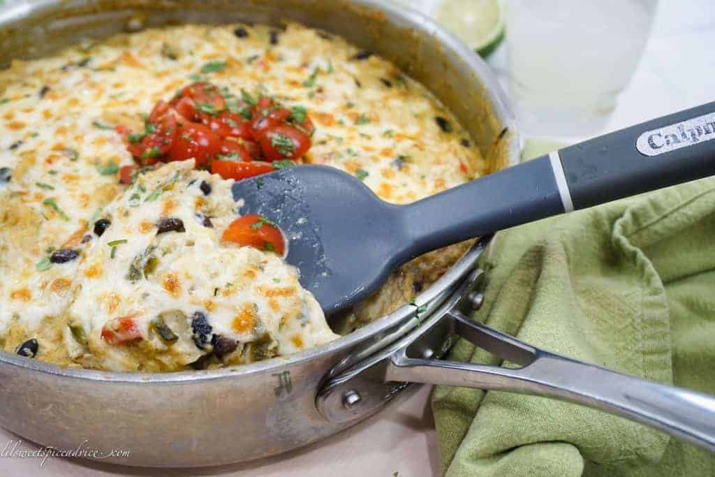 Roasted Poblano Chicken Enchilada Skillet -- Looking for a quick and easy dish to celebrate Cinco de Mayo or for Mexican inspired weeknight dish? This Roasted Poblano Chicken Enchilada Skillet will have dinner on the table in no time thanks to using torn corn tortillas, shredded rotisserie chicken, and homemade roasted poblano cream sauce. -- lilsweetspiceadvice.com #roastedpoblanochickenenchiladas #enchiladaskillet #roastedpoblanocreamsauce #chickenenchiladaskillet