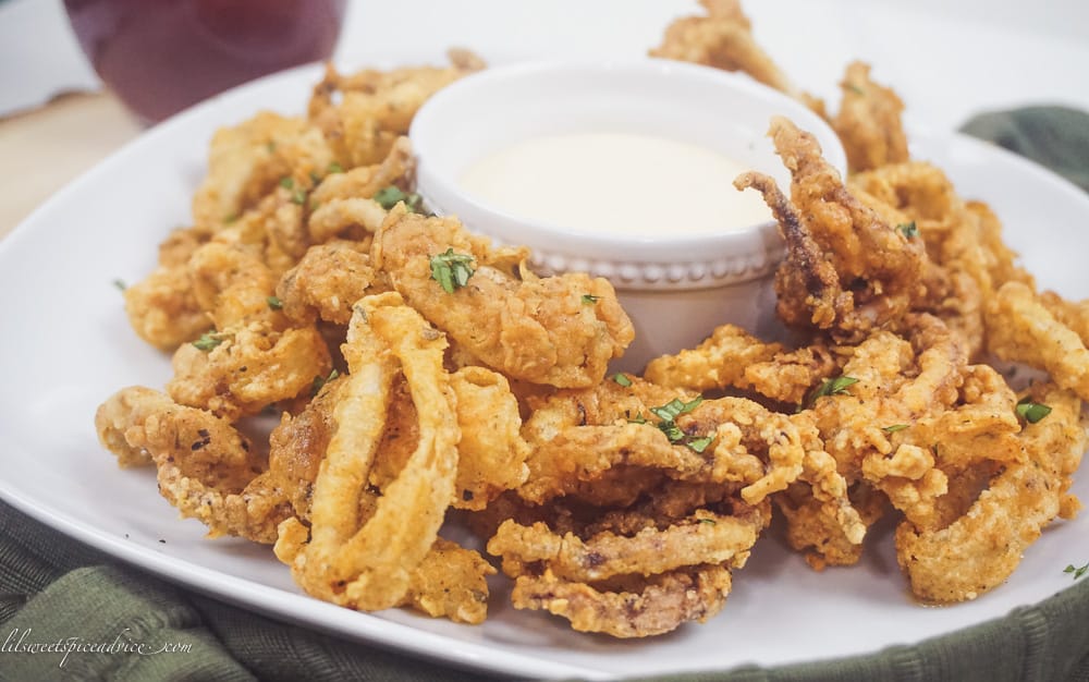 Gluten-Free Fried Calamari with Sriracha Lemon Basil Aioli -- These restaurant quality gluten-free fried calamari with sriracha lemon basil dipping sauce are sure to knock the socks off of all of your guests! They are perfectly seasoned, very crunchy yet tender. -- lilsweetspiceadvice.com #glutenfreefriedcalamari #friedcalamari #glutenfreeappetizers